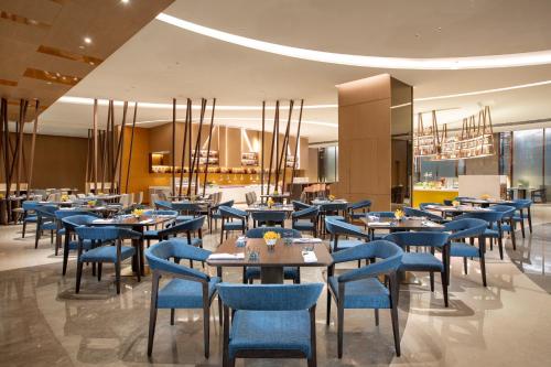 a dining room with blue chairs and tables at Holiday Inn Shunde by IHG in Shunde