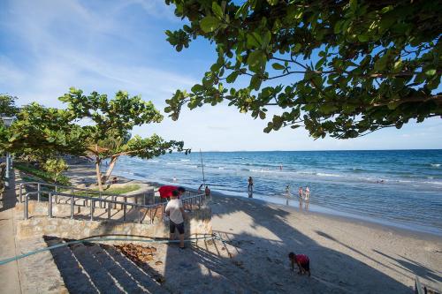 a person standing on a beach with two dogs at Avatara A Ocean Views by malai in Ban Tha Fat