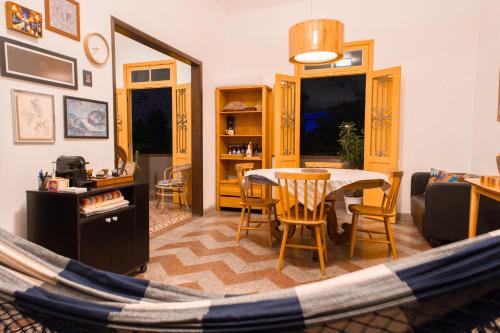 a hammock in a living room with a table and chairs at Sobrado Fundição in Recife