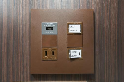 a brown wall with two signs on it at Hotel Amaterrace Yosuga in Osaka