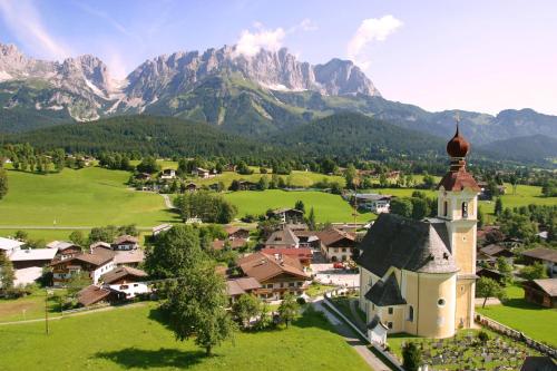an aerial view of a village with a church and mountains at Schnapperhof in Going