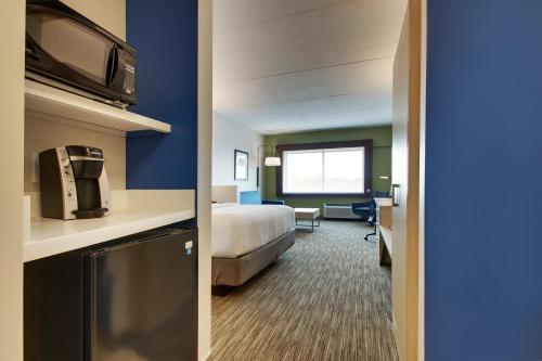 a hotel room with a bed and a room with a television at Holiday Inn Express & Suites - Elizabethtown North by IHG in Elizabethtown