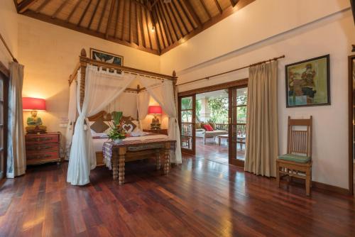 a bedroom with a bed and a desk in a room at Villa Kaja by Nagisa Bali in Seminyak