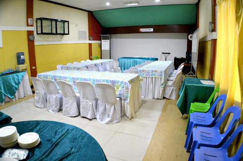 a room with several tables and chairs in a room at Rufina's Leisure Center in Tagum
