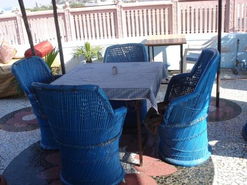 a blue table and chairs with a table and a table and chairs at Pushp Guest House in Jodhpur