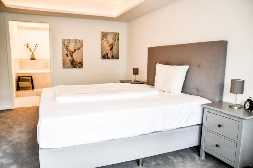 a bedroom with a large white bed and a table at Parkhotel FRITZ am Brunnen in Schwelm