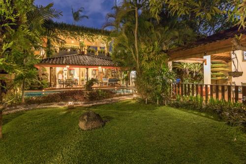 an exterior view of a house with a yard at Villa Kaja by Nagisa Bali in Seminyak
