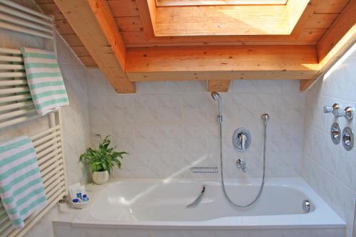 a bath tub in a bathroom with a wooden ceiling at Ferienhaus am Römerweg in Klais