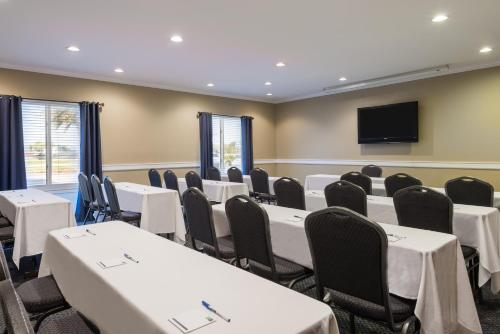 a conference room with tables and chairs and a flat screen tv at Holiday Inn Express Hotel & Suites New Iberia - Avery Island by IHG in New Iberia