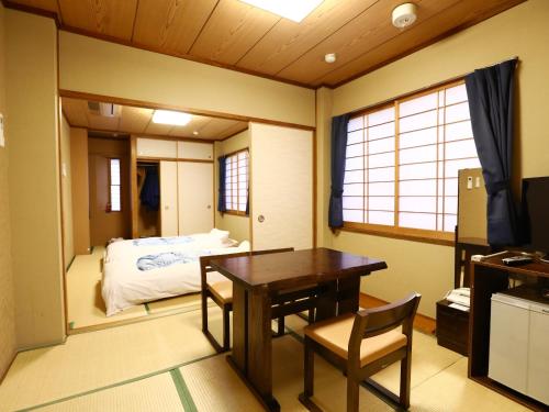 uma sala de jantar com uma mesa e uma cama em Ryokan Kamogawa Asakusa em Tóquio