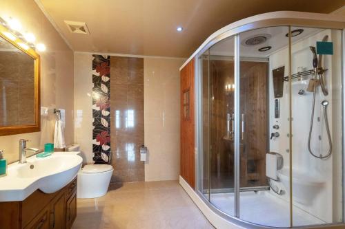 a bathroom with a shower and a sink and a toilet at Le Reve Valley - Canadian cottage 1 - 3BHK Luxury cottage,Bonfire,Barbeque,Gym,Kids play zone,Lake view in Bhowāli