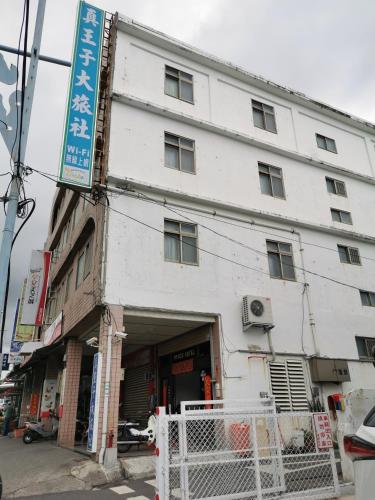 a white building on the corner of a street at Zhen Wang Zi Hotel in Chenggong
