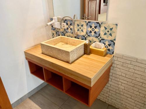 a bathroom with a wooden counter with a sink and a mirror at La Bella - Hotel Villa & Spa in Gili Trawangan