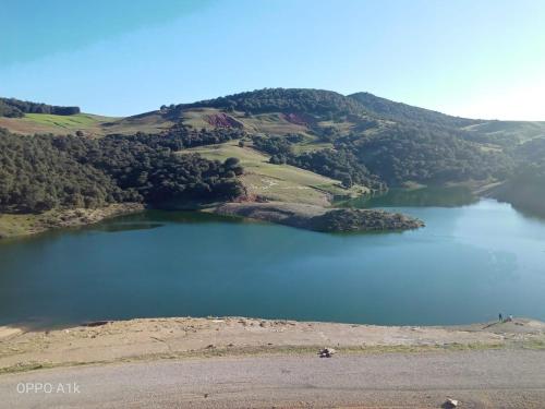 an island in a lake on top of a hill at Le Gite du Barrage in Zaouia Ben Smine