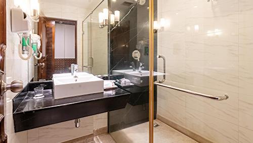 a bathroom with a sink and a shower at SFO Hotel and Suites in Bangalore