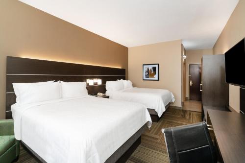 a hotel room with two beds and a television at Holiday Inn Express Hotel & Suites Ashland by IHG in Ashland