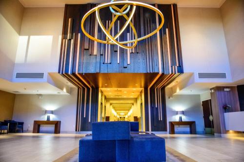a lobby with a blue chair and a chandelier at Crowne Plaza Dulles Airport by IHG in Herndon