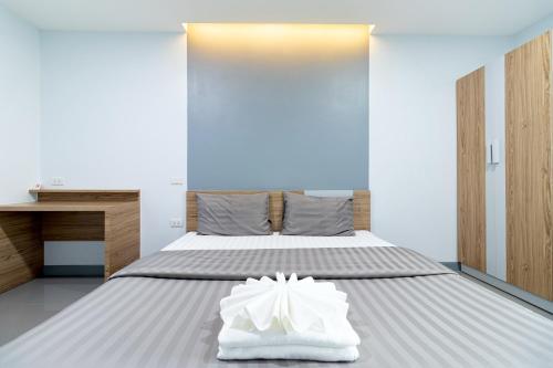 a bedroom with a bed with white shoes on it at BeWish Residence Bangphlat in Bangkok
