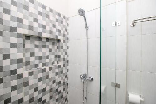 a bathroom with a shower with a glass door at RedDoorz Plus near Soekarno Hatta Airport Taman Mahkota in Tangerang