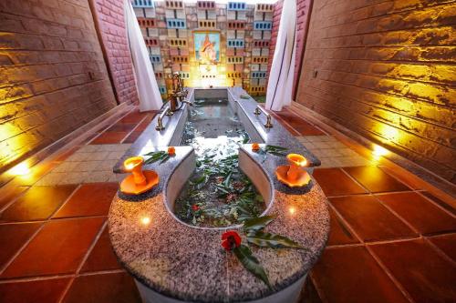 a bath tub with a fountain in the middle of a room at Ayurvie Sigiriya - Ayurvedic Retreat by Thema Collection in Sigiriya