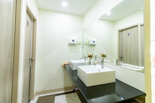 a bathroom with two sinks and a mirror at BeWish Residence Bangphlat in Bangkok
