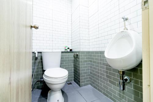 a bathroom with a white toilet and a urinal at BeWish Residence Bangphlat in Bangkok