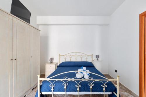 Un dormitorio con una cama azul con un osito de peluche. en Joy Home Apartments by BarbarHouse, en Maruggio