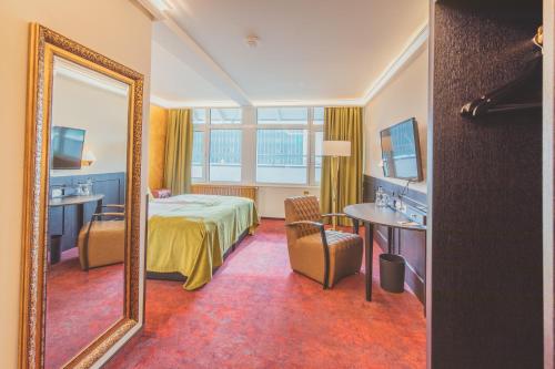 a hotel room with a bed and a mirror at Nordhäuser Fürstenhof & TinySky-Resort in Nordhausen