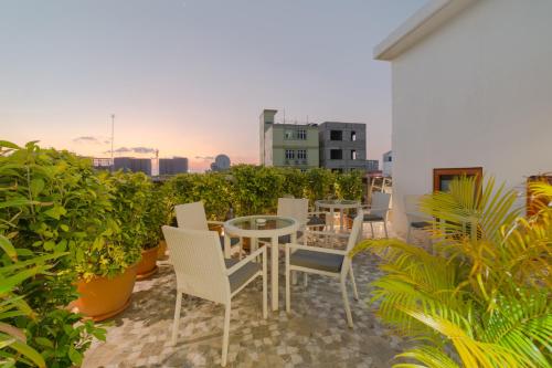 a patio with chairs and a table on a balcony at Samann Host in Hulhumale