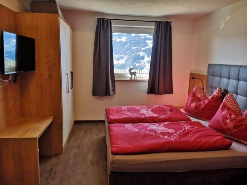 ein Wohnzimmer mit einem roten Sofa und einem Fenster in der Unterkunft Appartement Franz in Zell am Ziller