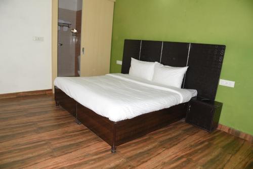 a bedroom with a large bed with white sheets at The Palm Tree -Family Stay in Amritsar