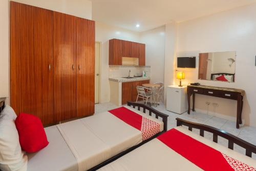 ein Wohnzimmer mit einem Bett und eine Küche in der Unterkunft OYO 556 3j's And K Apartment in Cebu City