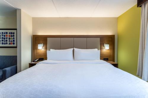 a large bed with white pillows in a hotel room at Holiday Inn Express & Suites Cedar Falls - Waterloo by IHG in Cedar Falls
