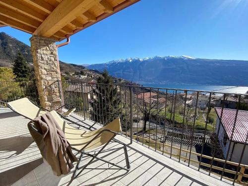 a chair on a deck with a view of the mountains at La Terrazza sul Lago, Tignale in Tignale