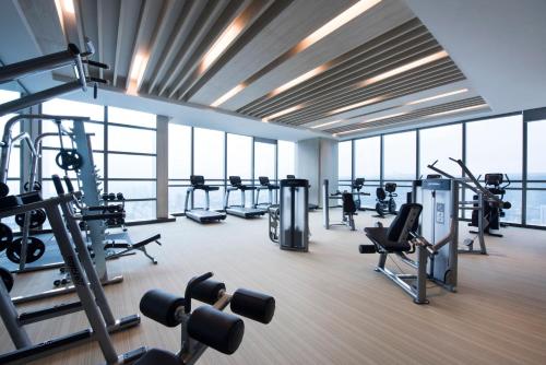 a gym with several treadmills and machines and windows at Crowne Plaza Baoji City Center by IHG in Baoji