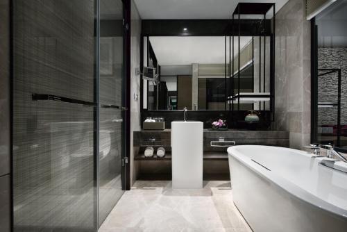 a bathroom with a tub and a sink and a mirror at Crowne Plaza Baoji City Center by IHG in Baoji