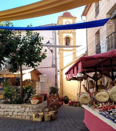 a market with baskets and a clock tower in the background at CASA RURAL LLAVADOR Vall Guadalest in Benifató