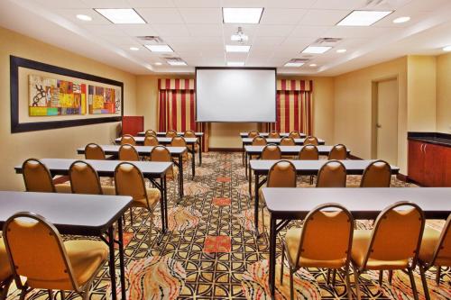 a conference room with tables and chairs and a projection screen at Holiday Inn Express Hotel & Suites Atlanta-Cumming by IHG in Cumming