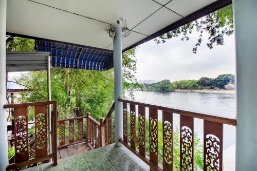a balcony with a view of the river at T & T Hostel Kanchanaburi in Kanchanaburi City