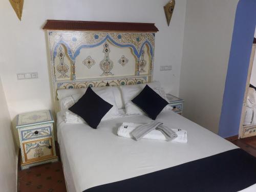 a hotel room with a white bed and white comforter at Casa El Haouta in Chefchaouen