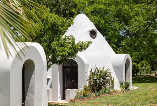 a white house with arches in a yard at Stellenhof Country Estate in Addo