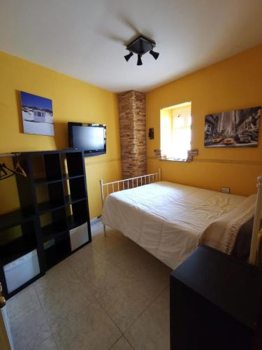 - une chambre avec un lit et un ventilateur de plafond dans l'établissement Casa Foz, à Foz