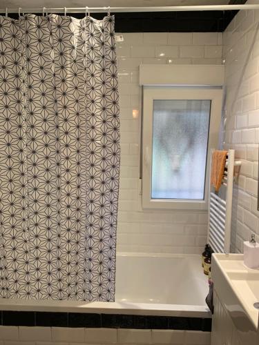 a bathroom with a tub and a shower curtain at Apartamento Colón VUT-47-132 in Valladolid