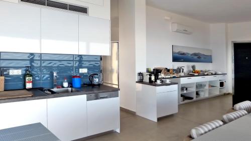 a kitchen with white cabinets and a counter top at Marathon Blue in Schinias