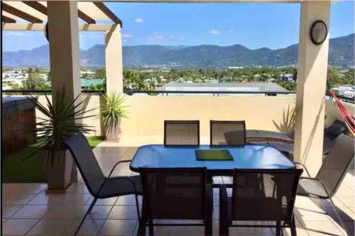 patio ze stołem i krzesłami na balkonie w obiekcie Beautiful Penthouse with Private Rooftop Spa, Gym, TV w mieście Cairns
