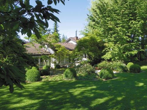a house with a yard with bushes and trees at Landhaus Ettenbühl Bed and Breakfast in Bad Bellingen
