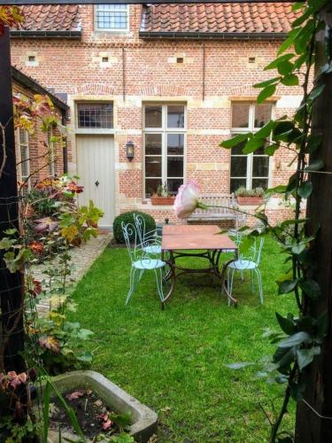 a patio with a table and chairs in a yard at B&B De Vrome Vos in Mechelen