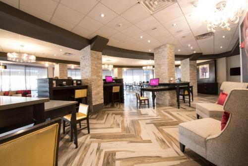 a lobby with tables and chairs in a building at Crowne Plaza Saddle Brook by IHG in Saddle Brook