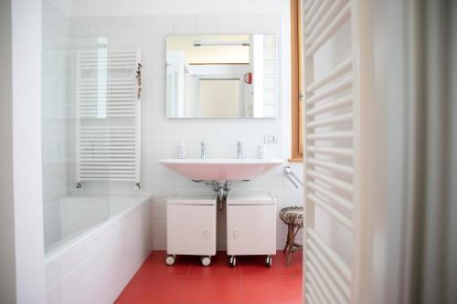 a bathroom with a sink and a tub and a mirror at IseoLakeRental - Casa Stella d'Acqua in Sulzano