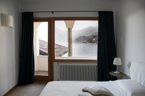 una camera da letto con finestra affacciata sull'acqua di IseoLakeRental - Casa Stella d'Acqua a Sulzano
